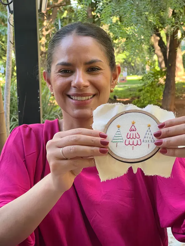 Aluna mostrando o bastidor de Natal recém-terminado
